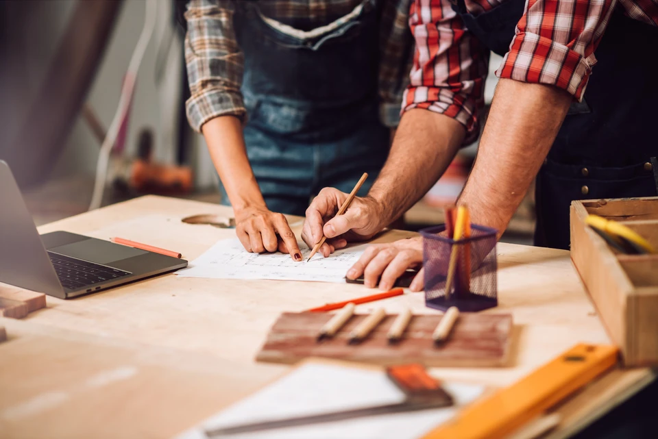 Artisan menuisier consulte une tablette numérique dans son atelier