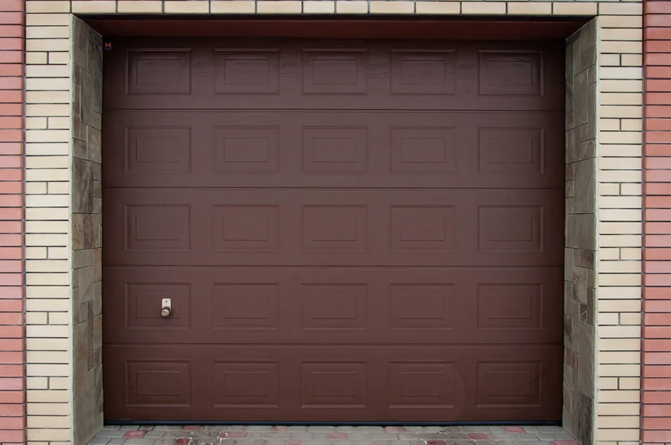 Façade extérieure d'un garage résidentiel avec deux portes sectionnelles blanches fermées, installées côte à côte