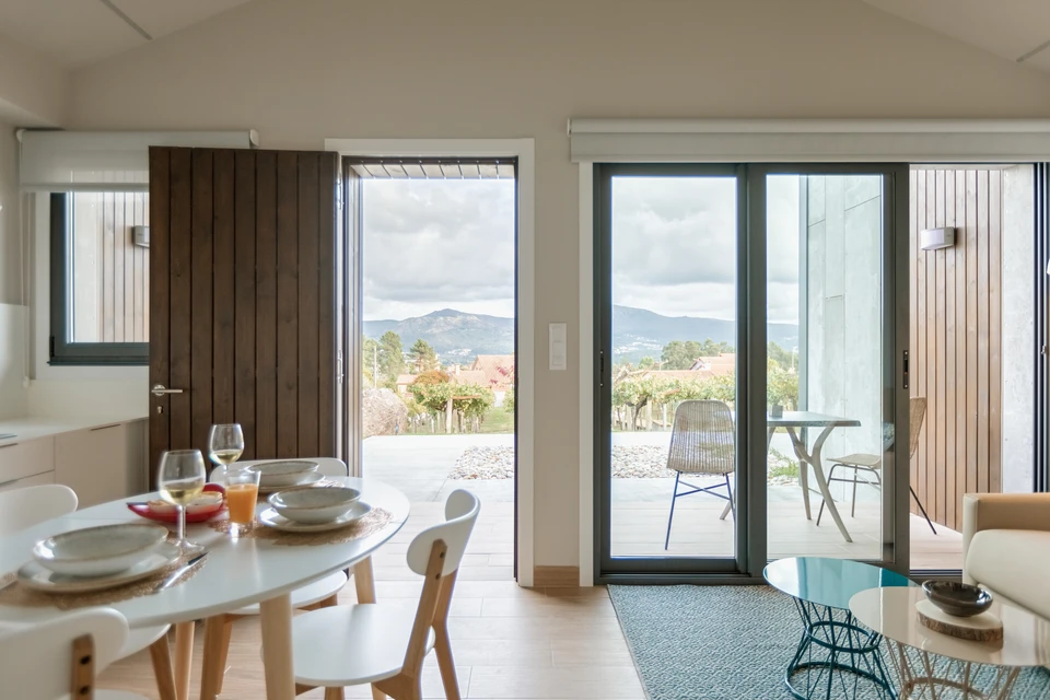 Intérieur moderne avec baie vitrée coulissante ouverte sur terrasse paysagée